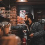 Jacket Café - A man standing in front of a coffee shop counter