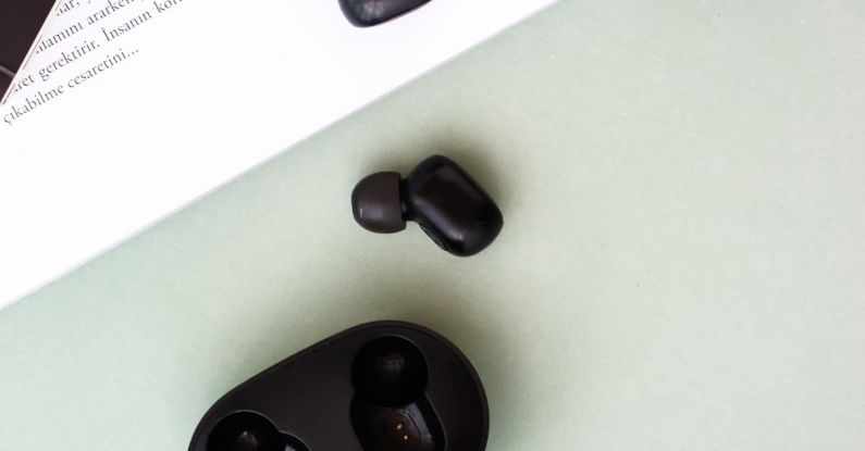 Holder Bike - A pair of black wireless earphones sitting on top of a book
