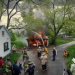 Team Blend - Firefighters and people stand around a house with a fire