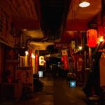 Shop Route - Narrow walkway between street shops with shiny lamps in Asian town at night