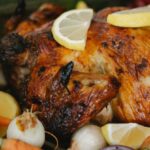 Roast Home - Roasted chicken with vegetables in glass roaster on table with fir sprigs